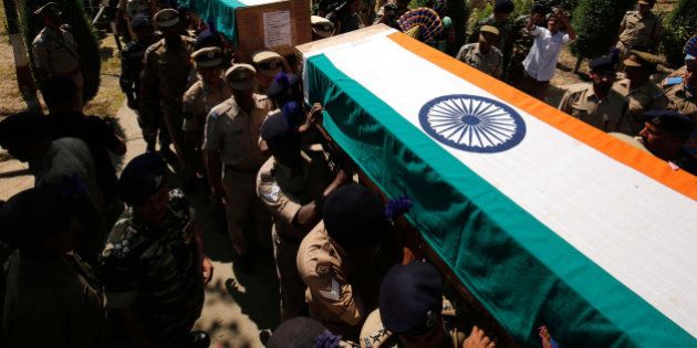 SRINAGAR, INDIA - JUNE 26: Senior police and paramilitary officers carry the coffins containing the bodies of slain Central Reserve Police Force (CRPF) men who had lost their lives in an encounter with Lashkar terrorists in Pampore during a wreath laying ceremony on the outskirts of Srinagar, on June 26, 2016 in Srinagar India. Eight Central Reserve Police Force men were killed and 20 others were injured after militants ambushed a convoy of the security force on the Srinagar-Jammu national highway in Jammu and Kashmir's Pulwama district. Two militants were also killed in the gunfight, the second major attack on a security convoy this month. (Photo by Waseem Andrabi/Hindustan Times via Getty Images)