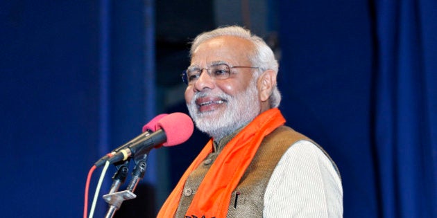 Hindu nationalist Narendra Modi, who will be the next prime minister of India, smiles as he addresses Gujarat state lawmakers and party workers during the appointment of the state's new chief minister in Gandhinagar May 21, 2014. Modi on Wednesday resigned as the state's chief minister and invited the leaders of Pakistan and other neighbours to his inauguration next week in an unprecedented move, signalling his aspirations to be a regional leader. REUTERS/Amit Dave (INDIA - Tags: POLITICS ELECTIONS)