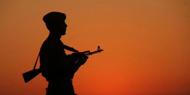 An Indian policeman is silhouetted against the setting sun as he stands guard on the banks of river Tawi ahead of India's Republic Day celebrations in Jammu January 23, 2012. India will celebrate its Republic Day on Thursday. REUTERS/Mukesh Gupta (INDIAN ADMINISTERED KASHMIR - Tags: MILITARY TPX IMAGES OF THE DAY)