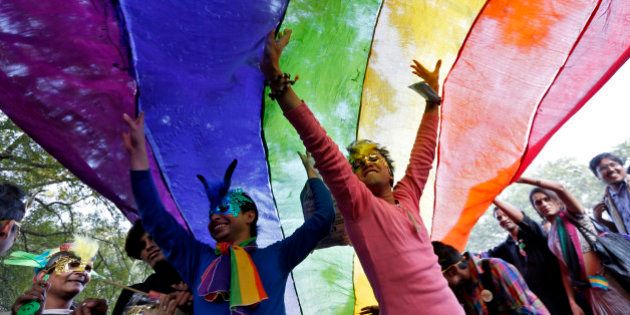 Participants dance under a a rainbow flag as they attend the sixth Delhi Queer Pride parade, an event promoting gay, lesbian, bisexual and transgender rights, in New Delhi November 24, 2013. Hundreds of participants on Saturday took part in a parade demanding freedom and safety of their community, according to a media release. REUTERS/Mansi Thapliyal (INDIA - Tags: SOCIETY TPX IMAGES OF THE DAY)