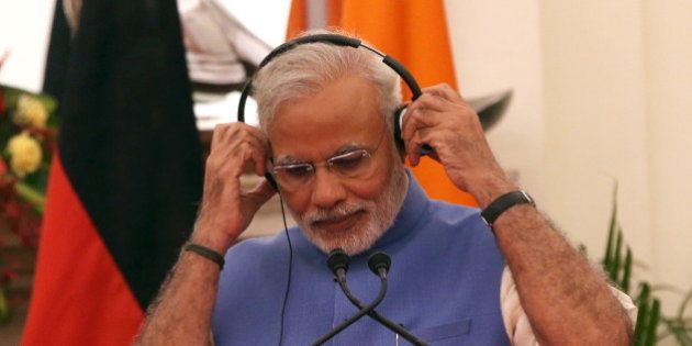 Indiaâs Prime Minister Narendra Modi adjusts his headphones during a joint statement with German Chancellor Angela Merkel (not pictured) after their delegation level talks at Hyderabad House in New Delhi, India, October 5, 2015. Merkel is on a three-day state visit to India. REUTERS/Adnan Abidi