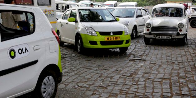 In this March 29, 2016 photo, Ola cabs, left, waiting for customers are parked next to other cars in Kolkata, India. Aiming to wrest control of Indiaâs booming taxi market, two cab-hailing smartphone apps, Uber and Ola, are promising hundreds of millions in new investments while also facing off with one another in court. (AP Photo/ Bikas Das)