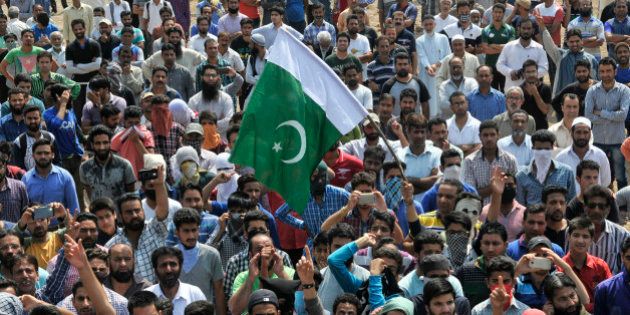 SRINAGAR, INDIA - JUNE 15: People shout anti-national slogans and raise flag of Pakistan during funeral of slain militant Tanveer Sultan, who was killed in a firing incident in Kud town of Udhampur district at Bemina on June 15, 2016 in Srinagar, India. The family claims he was a psychiatric patient and was travelling to Amritsar for treatment. The Jammu and Kashmir government confirmed that the person killed in a firing incident in Kud town of Udhampur district was a militant who had fired at the security forces. (Photo by Waseem Andrabi/Hindustan Times via Getty Images)