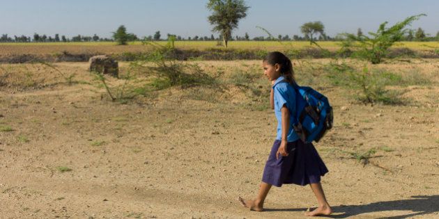 INDIA - MARCH 15: Young Indian girl in school uniform walking barefoot to her school near Rohet in Rajasthan, Northern India (Photo by Tim Graham/Getty Images)