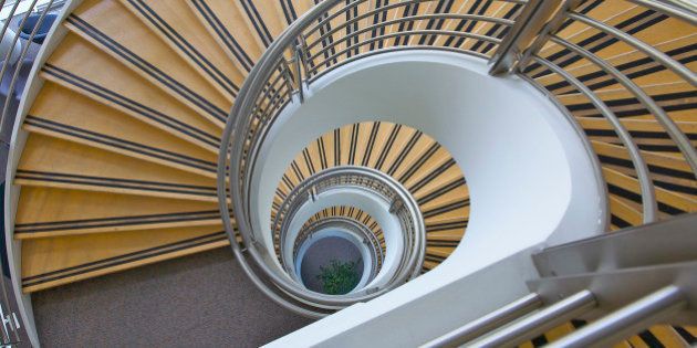 Multi-floor geometric spiral staircase looking downward