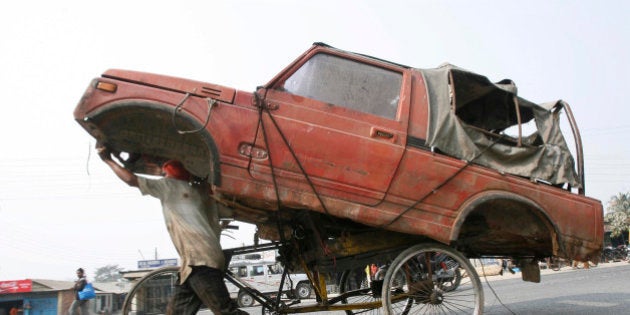 A cycle-rickshaw puller moves the wreckage of a car to a scrap yard in the eastern Indian city of Siliguri February 2, 2010. REUTERS/Rupak De Chowdhuri (INDIA - Tags: TRANSPORT SOCIETY IMAGES OF THE DAY) FOR BEST QUALITY IMAGE: ALSO SEE GM1E72E1CNX01