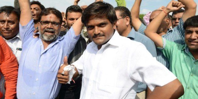 Hardik Patel (C), an organiser of the Patidar community, gathers with group members for a rally demanding 'Other Backward Class' (OBC) status in Ahmedabad on August 23, 2015. OBC members have urged the Gujarat government not to grant the Patel, or Patidar, community the status, which grants official protection of the members' social and educational development. AFP PHOTO / Sam PANTHAKY (Photo credit should read SAM PANTHAKY/AFP/Getty Images)