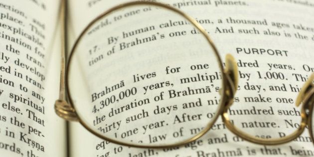 The Hindu Bhagavad Gita book with an old gold pair of glasses.