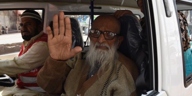 In this photograph taken on February 15, 2016, Abdul Sattar Edhi, the head of Edhi Foundation, waves as he journeys to his office in the port city of Karachi. He created a charitable empire out of nothing, masterminding Pakistan's largest welfare organisation. Today Abdul Sattar Edhi is revered by many as a national hero. / AFP / ASIF HASSAN / To go with ' Pakistan-Social-Health' FEATURE by Caroline Nelly Perrot (Photo credit should read ASIF HASSAN/AFP/Getty Images)