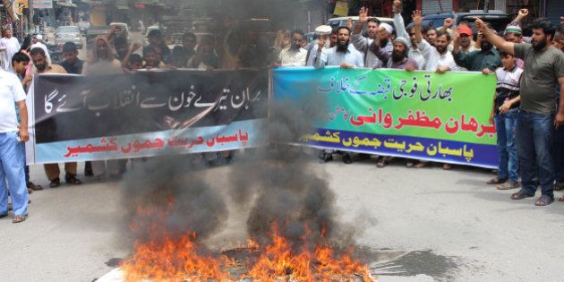 Pakistani Kashmiris burn the Indian flag during a protest against the killing of Burhan Muzaffar Wani, a top rebel commander, in Muzaffarabad, the capital of Pakistan-administered Kashmir on July 9, 2016. A top commander from the largest rebel group in Indian-administered Kashmir was killed in a gun battle with government forces on July 8, police said. Young and media savvy, Burhan Wani was a top figure in Hizbul Mujahideen and had a one million rupee ($14,900) bounty on his head. Wani, 22, joined the rebel movement at the age of 15 and in recent years had been behind a huge recruitment drive to the group's ranks, attracting young and educated Kashmiris to the decades-old fight for independence of the restive disputed region. Viewed locally as a hero, his death sparked protests in nearby Anantnag town, with hundreds taking to the streets shouting independence slogans and lauding Wani as a revolutionary, witnesses said. / AFP / SAJJAD QAYYUM (Photo credit should read SAJJAD QAYYUM/AFP/Getty Images)
