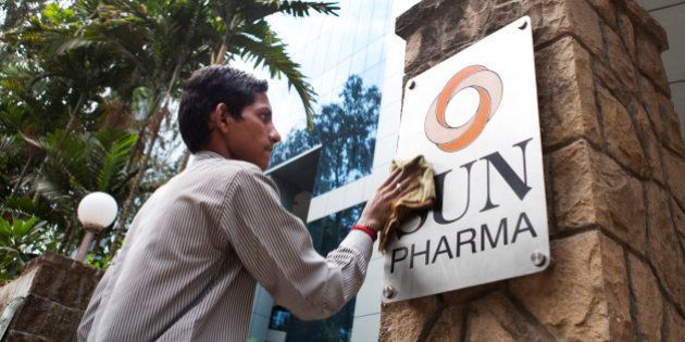 An employee cleans a sign outside the Sun Pharmaceutical Industries Ltd. corporate office in the Andheri suburb of Mumbai, India, on Monday, April 7, 2014. Sun Pharmaceutical, India's largest drugmaker by market value, agreed to buy Ranbaxy Laboratories Ltd. for $3.2 billion in stock, the biggest purchase by an Indian company in two years. Photographer: Amit Madheshiya/Bloomberg via Getty Images