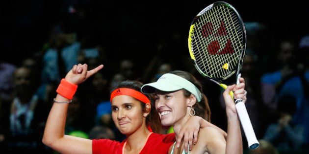 SINGAPORE - NOVEMBER 01: Sania Mirza of India and Martina Hingis of Switzerland celebrate defeating Carla Suarez Navarro and Garbine Muguruza of Spain in the doubles final match during the BNP Paribas WTA Finals at Singapore Sports Hub on November 1, 2015 in Singapore. (Photo by Julian Finney/Getty Images)