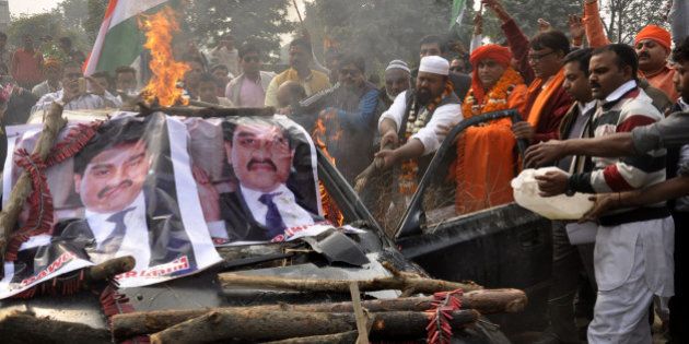 GHAZIABAD, INDIA - DECEMBER 23: Right wing activist Chakrapani Maharaj and his followers burned down an old car belonging to underworld don Dawood Ibrahim on December 23, 2015 in Ghaziabad, India. The car was procured through an auction in Mumbai earlier this month.Dawood is wanted in India for the 1993 serial bomb blasts in Mumbai that killed 257 people and injured nearly a 1,000 others. Jamiat Ulema-e-Hind president Maulana Suhaib Qasmi along with about a dozen supporters was also present. (Photo by Sakib Ali/Hindustan Times via Getty Images)