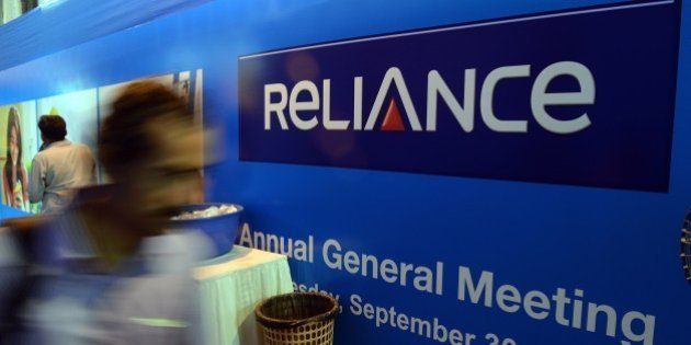 An Indian shareholder walks past a Reliance display at the Annual General Meeting of Reliance Group Companies in Mumbai on September 30, 2015. AFP PHOTO/ INDRANIL MUKHERJEE (Photo credit should read INDRANIL MUKHERJEE/AFP/Getty Images)