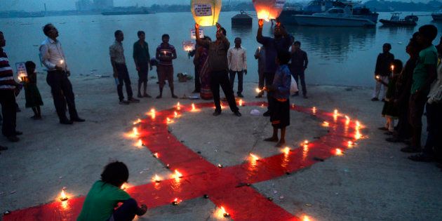 KOLKATA, INDIA - 2015/12/01: Social Activists observe World AIDS Day on the bank of the River Ganges in Kolkata. World AIDS Day is observed on December 01 every year to raise awareness about HIV/AIDS . To generate awareness activist light a big red ribbon and a gas balloons carrying message regarding eradication of stigma and panic discrimination on HIV/AIDS. (Photo by Saikat Paul/Pacific Press/LightRocket via Getty Images)