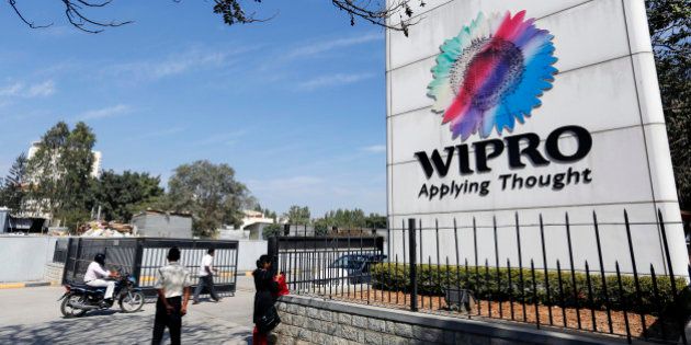 Employees walk past Wipro Ltd. signage as they enter the company's campus in Bangalore, India, on Tuesday, Jan. 28, 2014. Worldwide spending on information technology will grow 3.1 percent to $3.8 trillion this year, with IT services set to climb 4.5 percent, researcher Gartner Inc. forecast Jan. 6. Photographer: Vivek Prakash/Bloomberg via Getty Images
