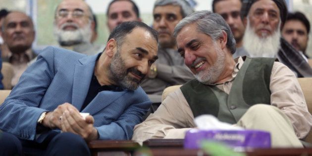 In this Tuesday, July 7, 2015 photo, Afghanistan's Chief Executive, Abdullah Abdullah, right, and Balkh acting governor, Ata Mohammad Noor, left, chat during a ceremony in Mazar-i Sharif, Afghanistan. Afghanistan's Chief Executive, Abdullah Abdullah visited northern Kunduz and Balkh provinces to meet with local political leaders and assure residents that insecurity and governance problems will soon be addressed. (AP Photo/Massoud Hossaini)