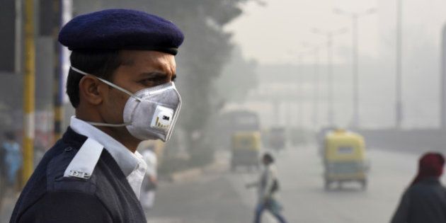 NEW DELHI, INDIA - JANUARY 4: People and traffic police wearing a mask during the implementation of odd-even vehicle formula at ITO crossing on January 4, 2016 in New Delhi, India. Contrary to apprehensions, Delhi's odd-even vehicle scheme aimed at battling pollution did not lead to the feared problems on Monday, the first full working day of the New Year. The 15-day odd-even scheme started on January 1 and aims to put odd numbered vehicles on the roads on odd dates and even numbered vehicles on even dates. (Photo by Arvind Yadav/Hindustan Times via Getty Images)