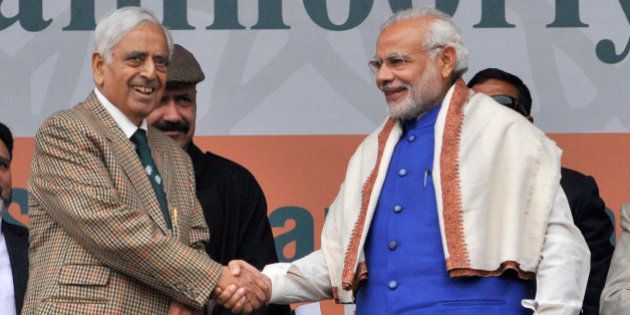 SRINAGAR, INDIA - NOVEMBER 7: Prime Minister Narendra Modi greets Jammu & Kashmir Chief Minister Mufti Mohammad Sayeed during a rally at the Sher-i-Kashmir cricket Stadium on November 7, 2015 in Srinagar, India. Modi announced a special package of Rs. 80,000 crore for Jammu and Kashmir and said that the governmentâs treasury is for the people. He said, 'If we can develop this, the youth will find employment right here. Friends, this development, in Jammu, Kashmir or Ladakh will always be our top agenda. And I dream of a new powerful, resurgent Kashmir.' (Photo by Waseem Andrabi/Hindustan Times via Getty Images)