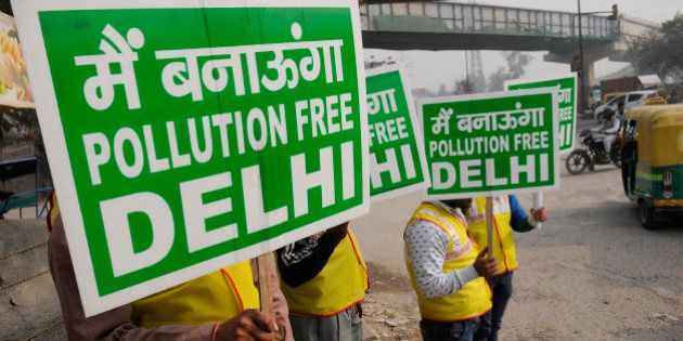 NEW DELHI, INDIA - JANUARY 1: Volunteers holding placards on the first day of Delhi's Odd-Even Vehicle Plan, on January 1, 2016 in New Delhi, India. The odd-even scheme that allows odd and even-numbered private vehicles to ply on city roads on alternate days aims at reducing air pollution levels. All diesel and petrol cars, irrespective of where they are coming from, will have to follow the rules. If a car is coming from out of Delhi and is breaking the odd-even rule, a fine will be levied. The government has deployed hundreds of volunteers and 3000 buses to help traffic police. To clean the Capital's toxic air, only odd-numbered private cars will be allowed on the road on odd dates and even-numbered on even days. Violators face a fine of Rs. 2,000. (Photo by Burhaan Kinu/Hindustan Times via Getty Images)