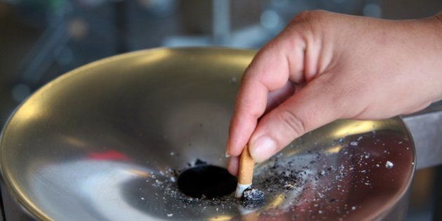 A women holds a cigarette over an ashtray in front of the train station in Gelsenkirchen, western Germany, on July 8, 2010. Buoyed by a referendum victory for a total ban on smoking in public places in Bavaria, Germany's anti-smoking lobby was pushing on July 6, 2010 for the habit to be stubbed out across the country. Sixty-one percent of people in the southern German state voted for the ban on July 4, meaning the tents at the world-famous Oktoberfest beer festival will be smoke-free from 2011. AFP PHOTO PATRIK STOLLARZ (Photo credit should read PATRIK STOLLARZ/AFP/Getty Images)
