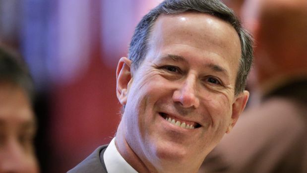 Former Pennsylvania Sen. Rick Santorum smiles at reporters while waiting for an elevator in Trump Tower in New York, Tuesday, Dec. 13, 2016. (AP Photo/Seth Wenig)