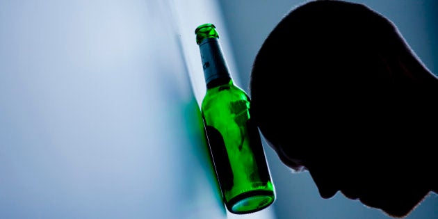 BERLIN, GERMANY - AUGUST 13: (EDITOR'S NOTE: In this photo illustration) A young man rests his head on a beer bottle on August 13, 2014 in Berlin, Germany. (Photo Illustration by Michael Gottschalk/Photothek via Getty Images)