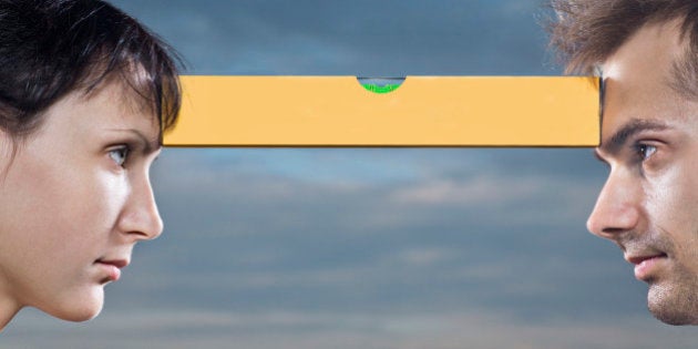 young woman and man face to face balancing spirit-level