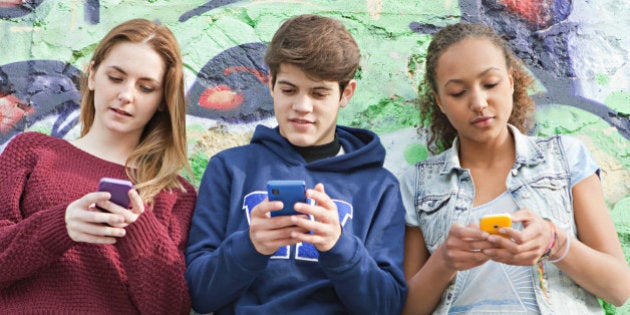 Teenagers using their smartphones simultaneously.
