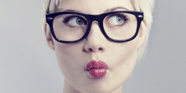 Nerdy and thinking girl with horned glasses. Naturally toned.