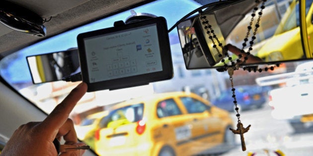 A taxi driver shows an application for smart mobile phones or tablets to order a 'safe taxi' ---wich in connected via GPS---- and able to report dangerous situations through the 'guardian angel' or 'panic button', in Bogota, Colombia, on July 3, 2013. A working group was created by authorities to find solutions for insecurity ---in both taxi drivers and passengers--- following the death of DEA's agent James Terry Watson, who was stabbed in a taxi in Bogota three weeks ago. AFP PHOTO/Guillermo LEGARIA (Photo credit should read GUILLERMO LEGARIA/AFP/Getty Images)