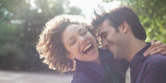Close up laughing couple hugging