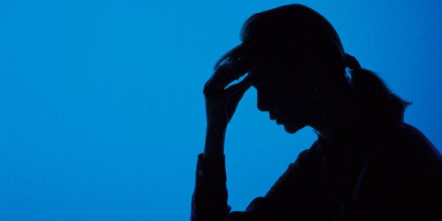 Silhouette of woman holding her head