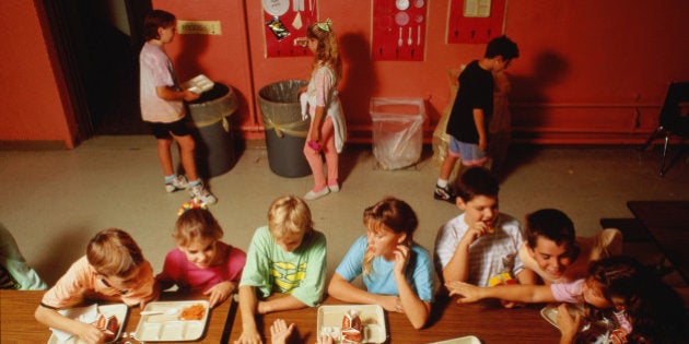 School children recycling eating utensils in refectory