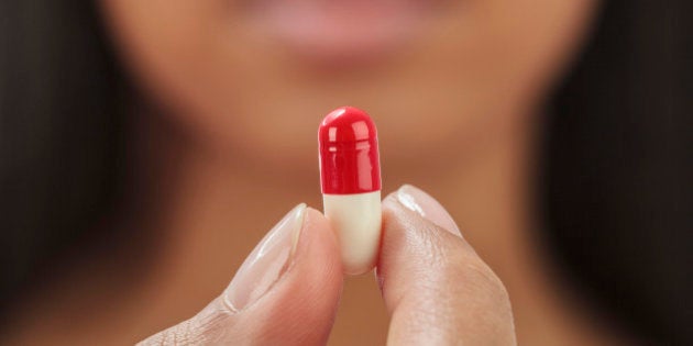 Close up of mixed race woman holding medication