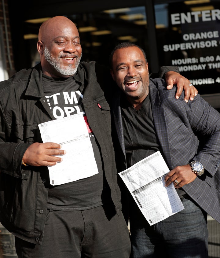 Former felons Desmond Meade, president of the Florida Rights Restoration Coalition, left, and David Ayala, husband of State Attorney Aramis Ayala, celebrate with copies of their voter registration forms after voters approved an initiative restoring voting rights to ex-felons in November.