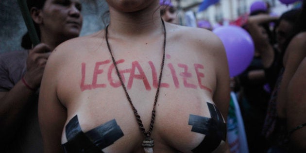 RIO DE JANEIRO, BRAZIL - MARCH 08: A supporter of legalizing abortion poses during a march for women's rights on International Women's Day on March 8, 2016 in Rio de Janeiro, Brazil. Marchers called for myriad reforms including protection from male violence and expanded female reproductive rights. Women's reproductive rights have taken on a new focus in Brazil following the onset of the Zika virus outbreak, which authorities strongly suspect is linked to birth defects. Brazilian law currently only allows abortion in cases of rape or certain dire health threats which do not include the Zika virus. (Photo by Mario Tama/Getty Images)
