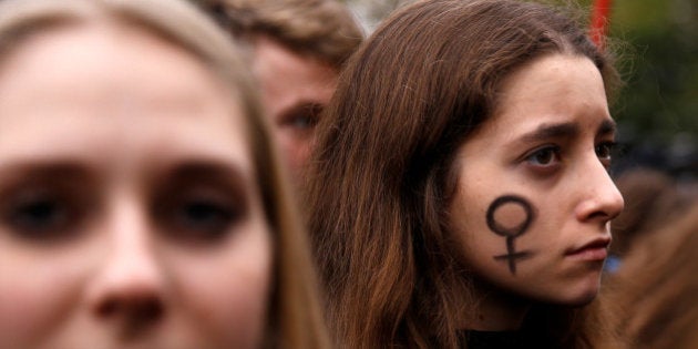 A woman looks on as people gather in an abortion rights campaigners' demonstration to protest against plans for a total ban on abortion in front of the ruling party Law and Justice (PiS) headquarters in Warsaw, Poland October 3, 2016. REUTERS/Kacper Pempel