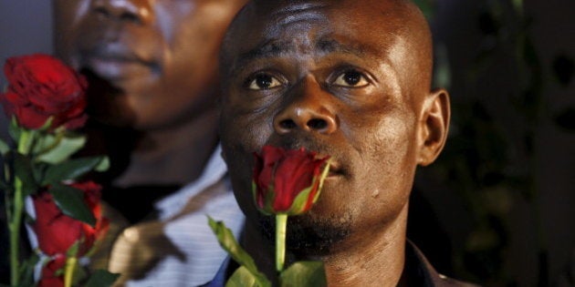 A man holds a rose as he mourns Kenyan soldiers serving in the African Union Mission in Somalia (AMISOM) who were killed during an attack last week, at a memorial vigil within the