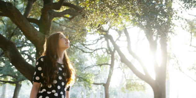 Portrait of young woman in forest,looking upward