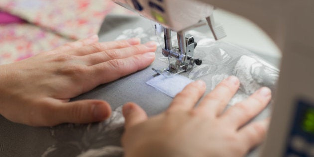 close woman hands sewing on sewing machine