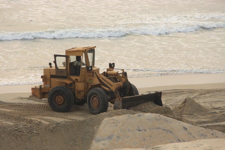 Earth movers in action at Alappad for mineral sand mining.