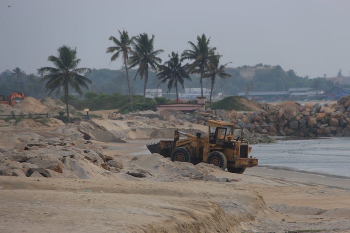 Earth movers digging mineral sand in Alappad.