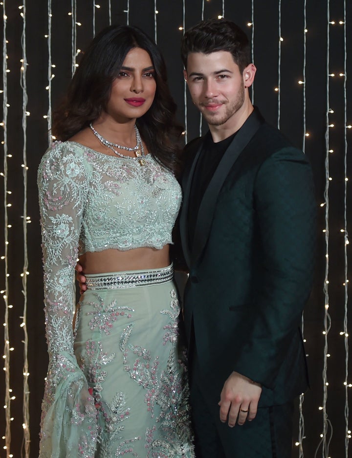 Priyanka Chopra and Nick Jonas pose together at a reception for their wedding in December. 