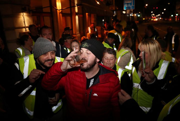 James Goddard drinks a pint of beer after being released from police custody on Saturday evening.