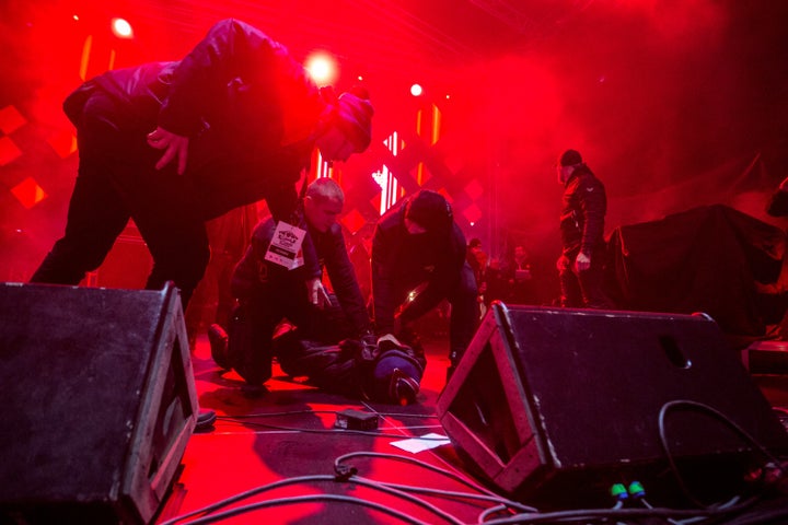 A man is held on the ground by security personnel after he attacked the mayor of Gdansk during a charity event in Gdansk on January 13, 2019.