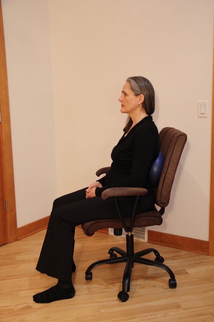 Bryan demonstrates how employees can use a fitness ball to retrofit an oversized office chair.