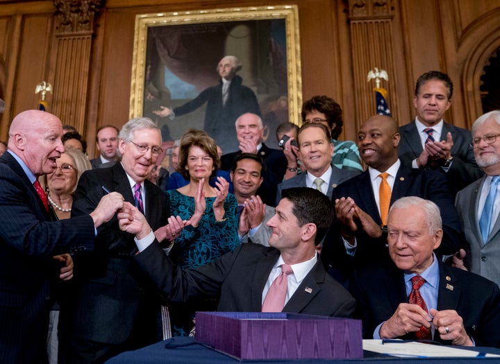 Lawmakers watch closely as Pres. Ronald Reagan signs into law a landmark tax overhaul on the White House South Lawn, Oct. 22, 1986, Washington, D.C. From left, are: Senate Majority Leader Robert Dole of Kansas, Rep. Raymond McGrath, R-N.Y.; Rep. Dan Rostenkowski, D-Ill., Rep. Frank Guerini, D-N.J.; Sen. Russell Long, D-La.; Rep. William Coyne, D-Pa., and Rep. John Duncan, R-Tenn. 