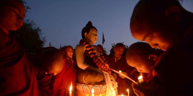 Novice Buddhist monks offer prayers by candle-light for a 16 year old gang rape victim at Tergar Monastery in Bodhgaya on January 3, 2014. An Indian teenager near the eastern city of Kolkata has been gangraped twice and then burned alive, police said, sparking protests after she died of her injuries. AFP PHOTO (Photo credit should read STR/AFP/Getty Images)