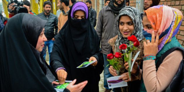 SRINAGAR, KASHMIR- NOVEMBER 12: A group of Muslim girls present red roses to the Muslim girls for wearing Hijab during a campaign on November 12, 2015 in Srinagar, the summer capital of Indian administered Kashmir, India. A Muslim group, the International Muslim Unity Council (IMUC), offered red roses to girl students outside a college to promote the wearing of the hijab (full body veil). A group of girls, associated with the IMUC, stood outside the college and distributed roses, scarves, stoles and religious pamphlets to girl students. The group said the hijab campaign was part of the ongoing campaigns in New Delhi's Jawaharlal Nehru University, Uttar Pradesh's Aligarh Muslim University and Hyderabad University in India. The group is planning to target other educational institutions too and claims that use of the hijab was going down in the Muslim majority region. (Photo by Yawar Nazir/Getty Images)